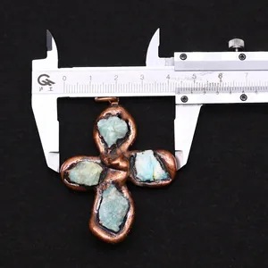 Macro view of bronze four-leaf flower pendant with blue raw stones measured by caliper