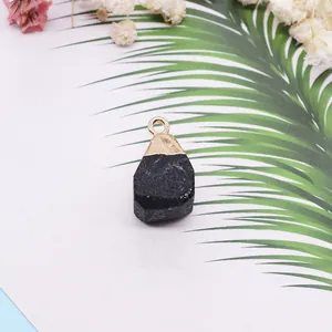 Pendentif en pierre noire naturelle cube avec calotte dorée et feuilles de palmier