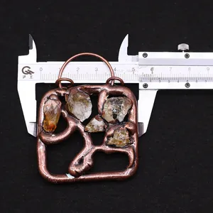 Detail shot of vintage bronze square pendant with natural citrine stones and ruler measurement