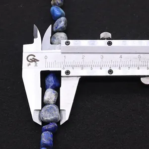 Détail macro d'une perle en lapis-lazuli naturel de 8-10 mm mesurée avec un étrier