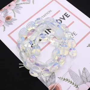 Perles d'opale blanche irrégulières au lustre iridescent sur une carte décorative