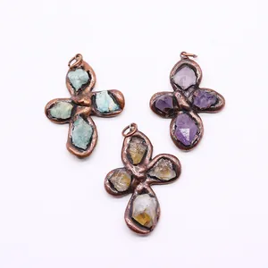 Three cross-shaped antique bronze pendants with natural green, purple, and citrine stones