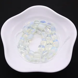 Perles d'opalite irrégulières pour bijoux DIY sur une assiette décorative blanche