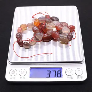 Macro-opname van 37,8g natuurlijke onregelmatige agaatkralen op een digitale weegschaal