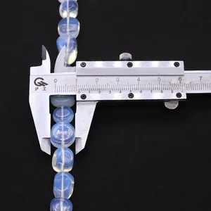 Pied à coulisse mesurant une perle d'opale bleue translucide de 12 mm sur fond noir