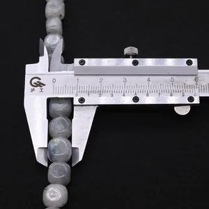 Macro shot measuring an 8.8mm natural labradorite bead with a digital vernier caliper