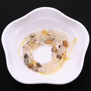 Irregular natural agate beads on a white floral tray for DIY jewelry making