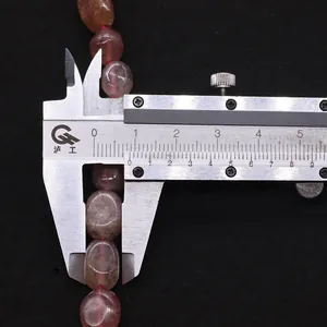 Mesure précise d'une perle en quartz fraise naturel avec un pied à coulisse argent