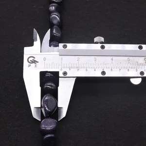 Mesure de perles irrégulières en grès bleu avec un pied à coulisse pour les bijoux DIY