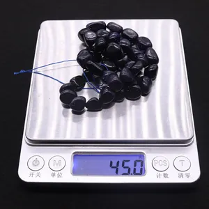 Macro de perles de grès bleu irrégulières sur une balance pesant 45 grammes pour bijoux