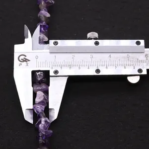 Macro detail of irregular purple amethyst beads measured with calipers showing 8-10mm size