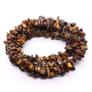 Irregular natural tiger eye stone chips strand with silky luster on white background