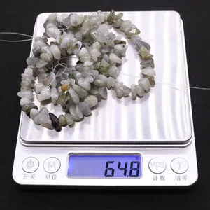 Macro di 64,8g di perle in labradorite naturale su una bilancia digitale argentata
