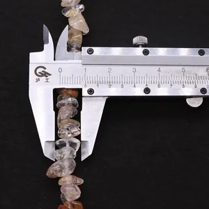 Measuring natural irregular rutilated quartz stone bead size with a digital caliper
