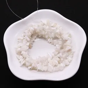 Irregular natural white moonstone chip beads for DIY necklace jewelry making on ceramic plate