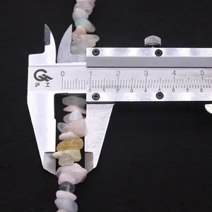 Macro detail of natural irregular gemstone beads being measured with a caliper