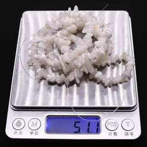 Irregular white moonstone chips on a digital scale showing weight for DIY jewelry