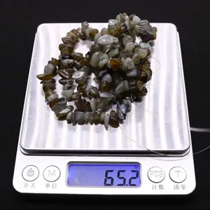 Vista macro di 65,2g di perle di labradorite naturale su una bilancia in acciaio inox