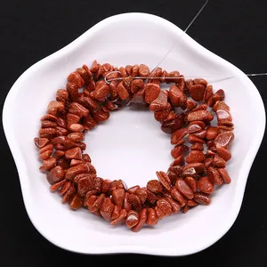 Polished irregular goldstone beads on a white star plate for DIY jewelry making