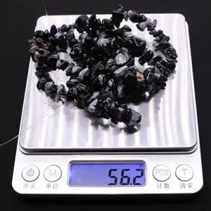 Macro shot showing 56.2g weight of natural irregular snowflake obsidian beads on a scale