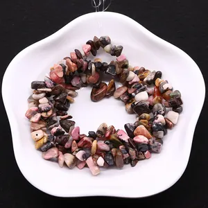 Natural irregular gemstone beads in white ceramic dish with black background