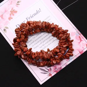 Irregular reddish brown goldstone chips beads with metallic shimmer on a floral card