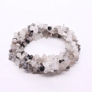 Polished irregular black rutilated quartz crystal beads on a white background