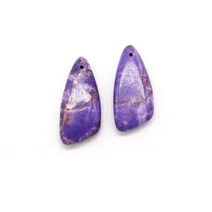 Close-up of two purple triangle stone pendants with natural textures and pre-drilled holes