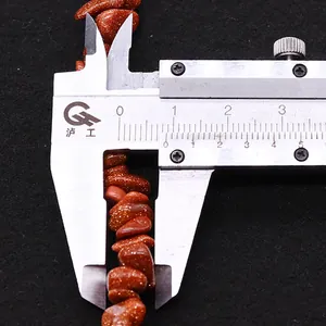 Macro view of 8-9mm irregular red goldstone beads measured with a stainless caliper