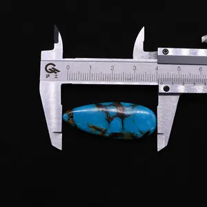 Mesure du pendentif goutte en pierre impériale avec un pied à coulisse sur fond noir