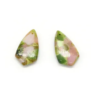 Macro detail of polished teardrop synthetic turquoise pendants in pink and green patterns