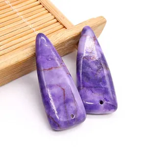 Dettaglio di ciondoli triangolari in pietra imperiale viola naturale con fori per gioielli DIY