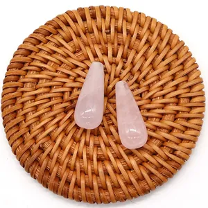 Macro view of teardrop rose quartz stones with natural texture on a woven tray