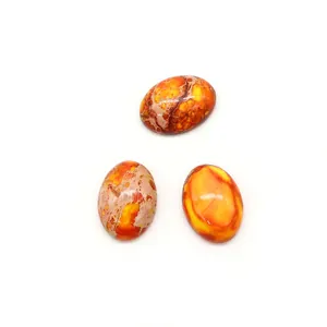 Gros plan de trois pierres naturelles ovales polies aux textures orange pour bijoux DIY