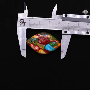 Macro view of teardrop natural stone pendant measuring 40mm with a digital caliper