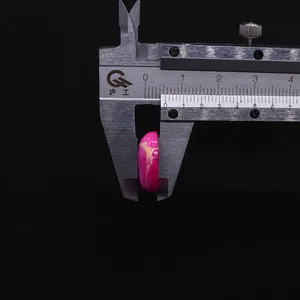 Vue macro d'une perle ovale en pierre empereur de 8 mm mesurée avec un étrier