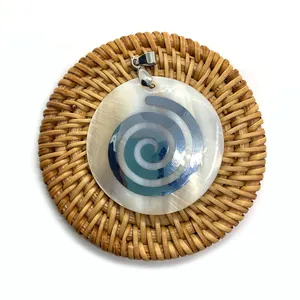 Détail macro du pendentif en nacre naturelle avec spirale en métal sur support tressé