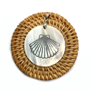 Macro d'un pendentif en nacre naturelle avec crochet argenté sur fond de tapis tressé