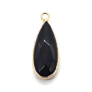 Detail of faceted black teardrop pendant with gold-plated bezel for jewelry making