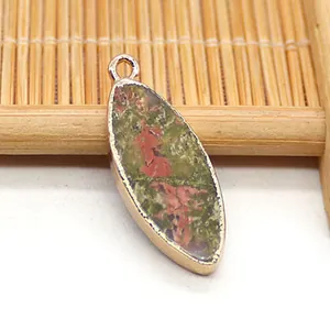 Vista macro de colgante de piedra natural marquesa con borde chapado en oro verde y rojo