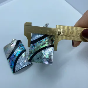 Macro della misurazione di un ciondolo in conchiglia di abalone da 32 mm con calibro