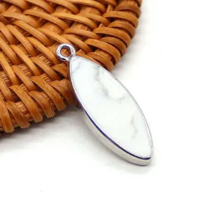 Vista macro del ciondolo turchese bianco a forma di marquise con montatura in argento