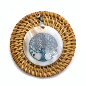 Pendentif en nacre naturelle avec arbre de vie en métal argenté sur plateau tressé