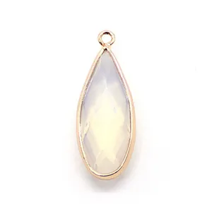 Detailed macro view of a teardrop-shaped white opal stone pendant with gold-plated metal trim
