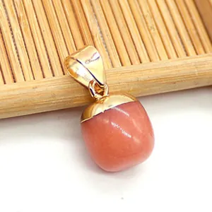 Nahaufnahme eines tropfenförmigen rosa Natursteinanhängers mit goldener Metallschließe