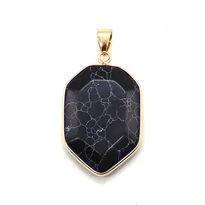Close-up of faceted white turquoise shield pendant with gold plated metal border and loop