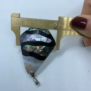 Misurazione della larghezza del ciondolo in conchiglia di abalone con calibro in ottone