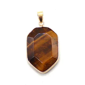 Macro view of shield-shaped tiger eye stone pendant with gold plating and hexagonal facets