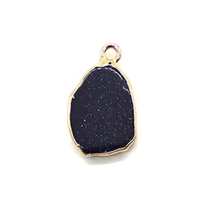 Close-up of blue goldstone pendant with gold plated edge and irregular shape