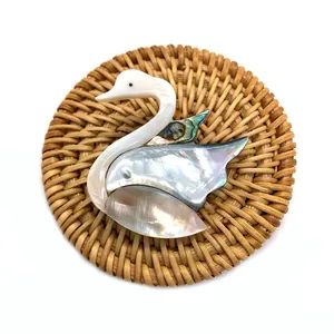 Pendentif cygne en nacre naturelle avec texture irisée et incrustations de coquillages